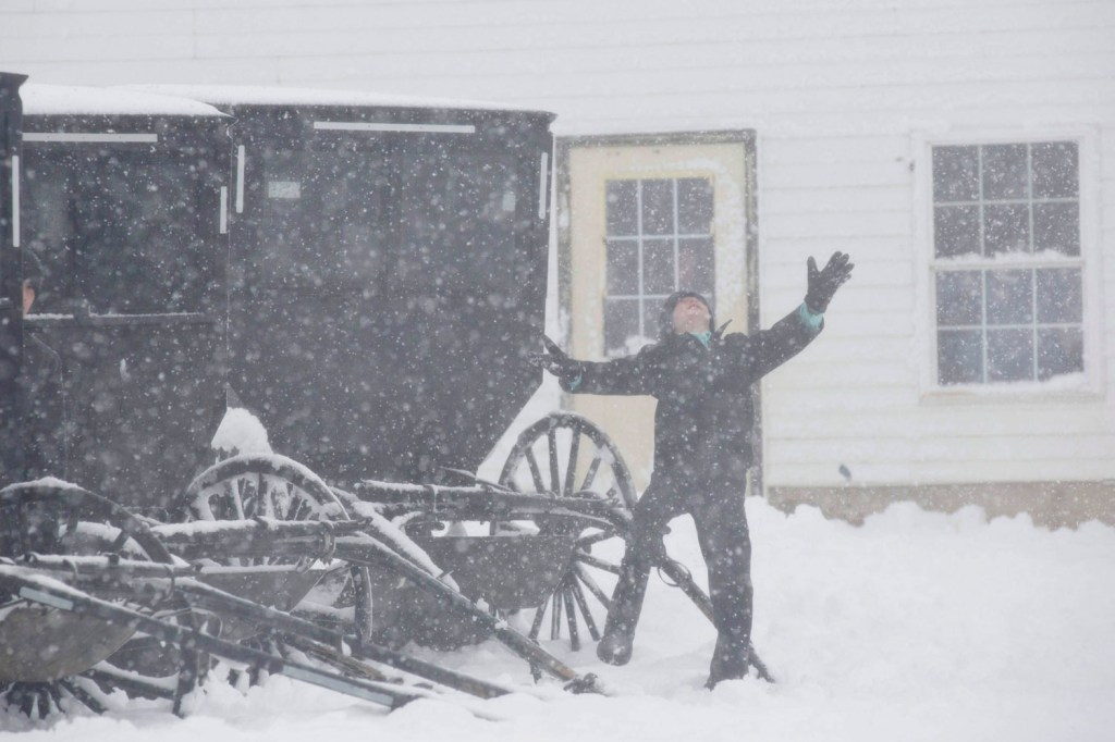 image: An Amish boy plays in snow outside a one room school house in Kingston Wis., December 20, 2012.