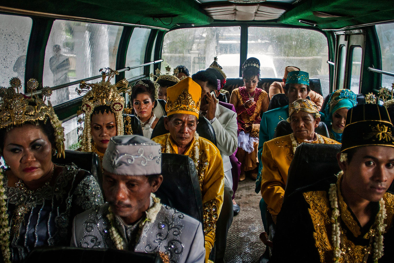image: Brides and grooms ride a bus in a parade during a mass wedding ceremony in Yogyakarta, Indonesia.