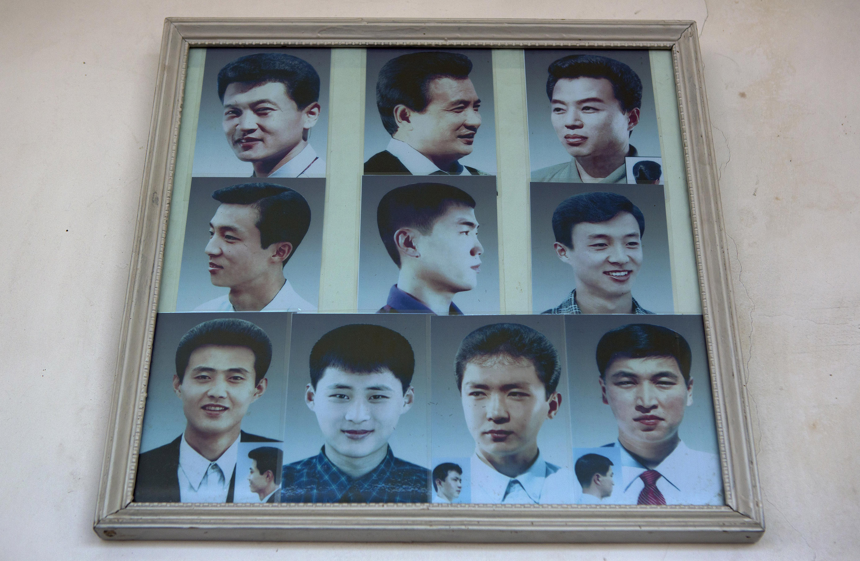 Photos showing example hair styles hang inside a barber shop in Pyongyang, North Korea on Feb. 20, 2013.