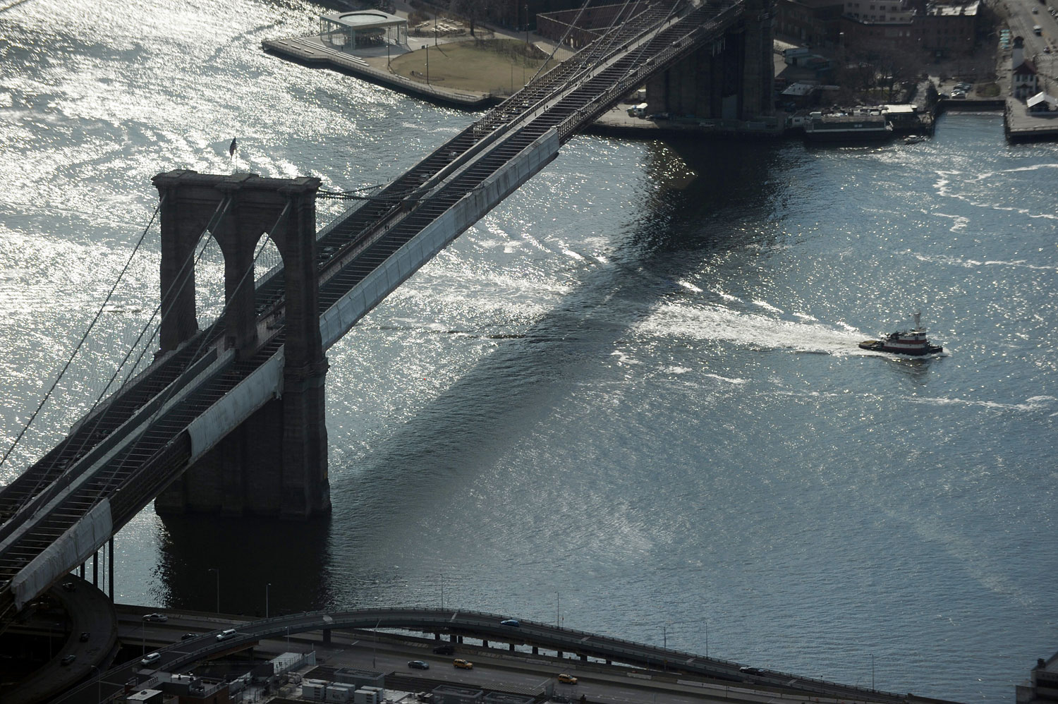 A tug boat passes under the Brooklyn Bridge as seen from One World Trade Center April 2, 2013 in New York.