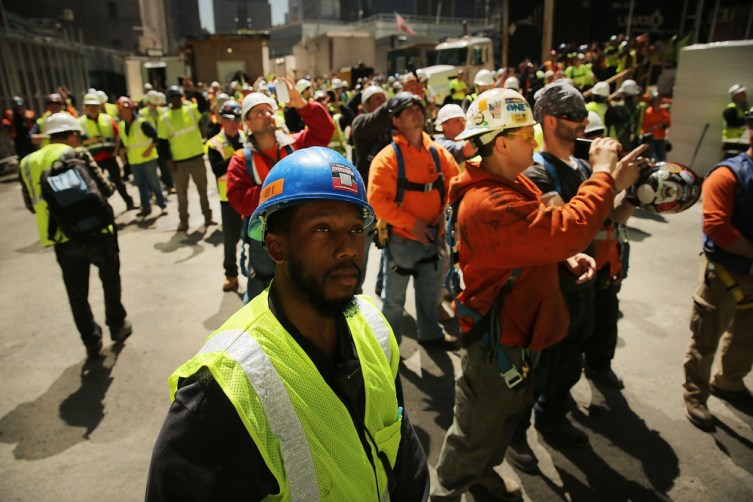 Construction workers watch as the 408-foot spire is hoisted onto a temporary platform on the top of One World Trade Center on May 2, 2013 in New York City.