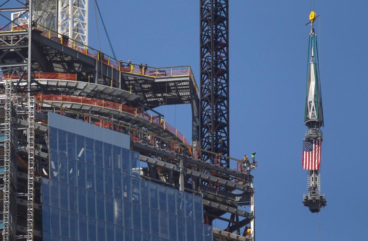The final section of the spire that will top off One World Trade Center is raised to the top of the building in New York
