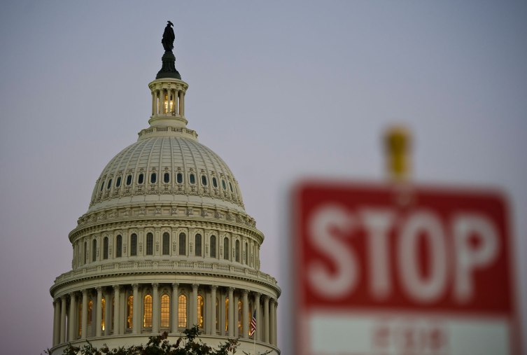 A stop sign is seen at dusk next to the US Congress building on the eve of a possible government shutdown as Congress battles out the budget in Washington, DC, September 30, 2013.
