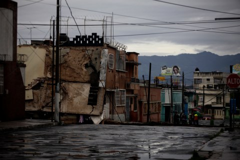 Neighbors gather near the site of a sinkhole in Guatemala City