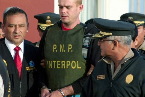 Dutch Joran Van de Sloot is escorted by police officers at the Santa Rosa border compound, in Tacna, Peru