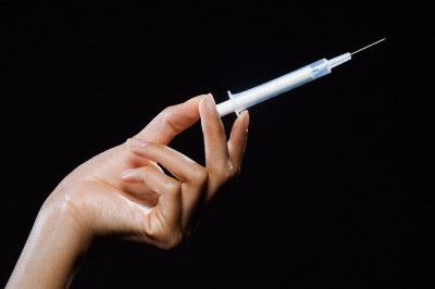 Hand holding hypodermic needle