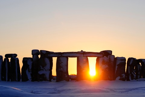 The sun sets behind Stonehenge in Wiltshire