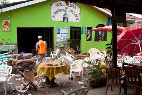 An investigator walks through the remains of an Ethiopian-themed restaurant that was hit by an explosion in Kampala