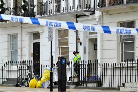 A police officer guards a property in Pimlico in central London