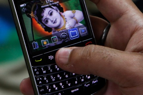 A customer checks the features of a Blackberry handset at a mobile showroom in New Delhi