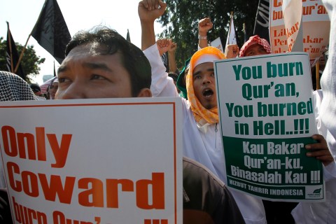 Members of the Islamic group Hizbut Tahrir Indonesia hold placards during a protest in front of U.S. embassy in Jakarta