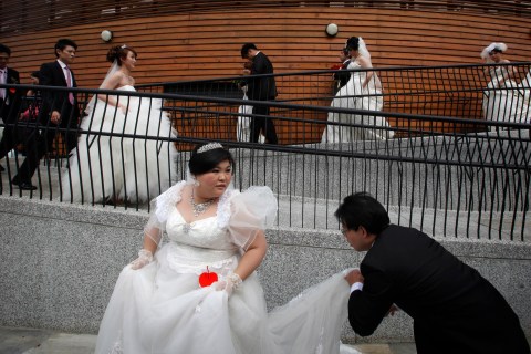Couples walk down a slope to line up before a mass wedding ceremony at the Taipei Flora Expo Hall, Taiwan