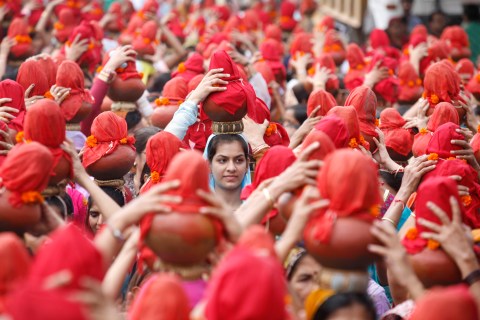 People carry earthen water pots as they take part in a Jhulelal Chaliha procession in Ahmedabad