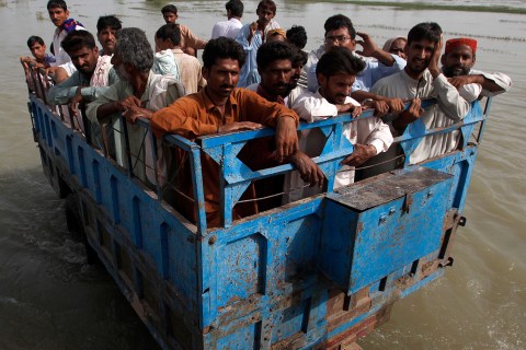 Flood victims travel in a tractor trolley as they return to their flooded village of Sultan Kot, in Sindh province