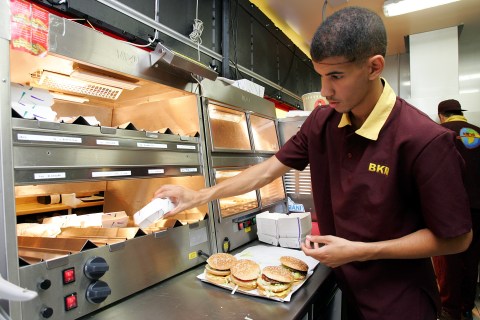 An employee prepares halal burgers 