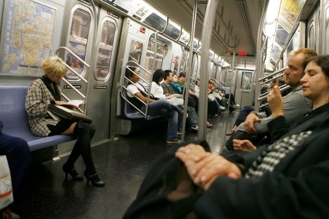 Commuters ride a subway car in New York