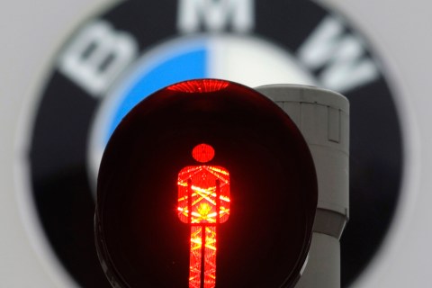 The logo of German luxury carmaker BMW is pictured behind a red traffic light at the company's headquarters in Munich