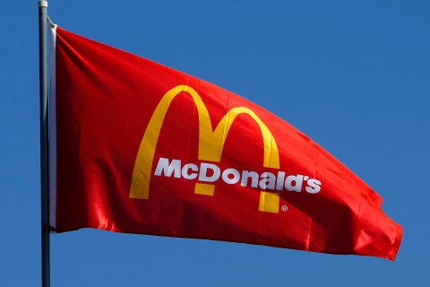 A flag blows in the wind above a McDonald's restaurant