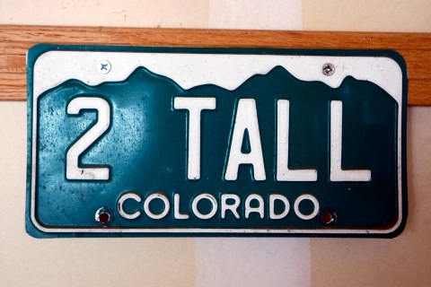 An old automobile license plate hangs in the garage of the Kotzians in Thornton