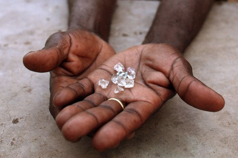 An illegal diamond dealer from Zimbabwe displays diamonds for sale in Manica