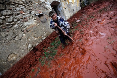 An elderly man tries to clean up his home in the flooded village of Devecser