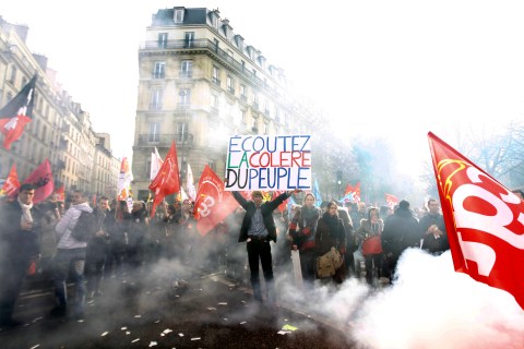 A man holds a placard during a demonstration in front of the French Senate in Paris