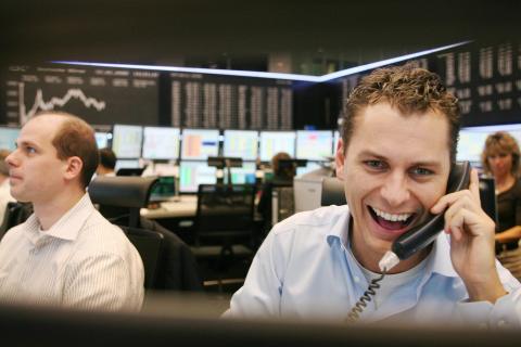 Two stock traders smile 