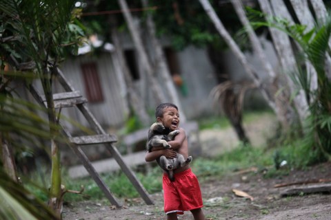 A boy holds his dog in Santa Izabel do Rio Negro