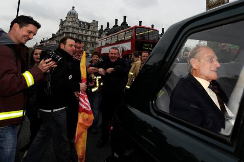 Britain's Prince Philip sits in his chauffered car as it is caught in traffic caused by protesting fire fighters walking towards Downing Street in London