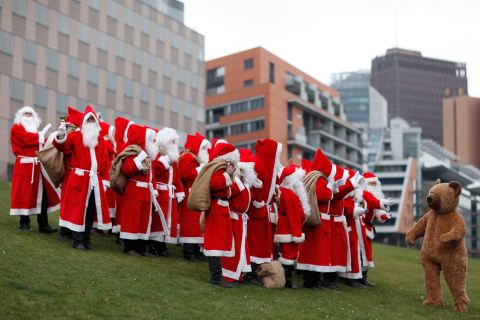 People dressed in Santa Claus and fairy costumes pose for pictures after annual meeting of rent-a-Santa Claus service in Berlin