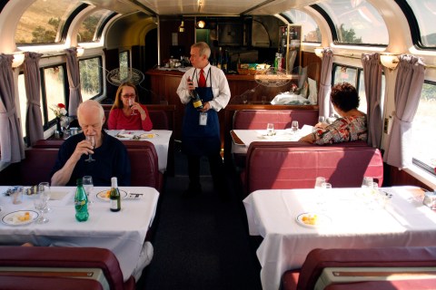 Amtrak train attendant Richard Newberry serves wine to passengers aboard the Coast Starlight Amtrak train during a wine tasting in California