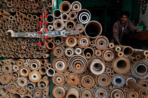 A worker sits inside a shop at a wholesale iron market in Kolkata