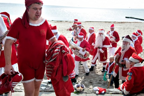 A man dressed as Santa Claus carries his belongings after a traditional bath at Bellevue Beach