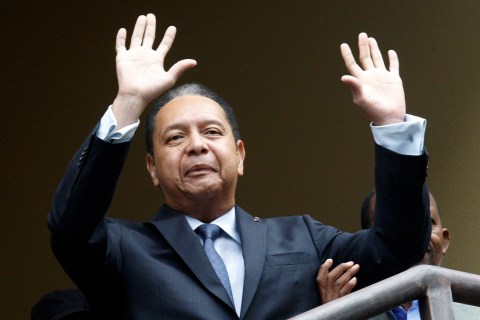 Duvalier greets the crowd before being escorted from his hotel by police in Port-au-Prince