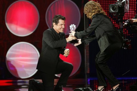 Presenter Josh Brolin kneels as actress Melissa Leo takes the stage to accept the award for best supporting actress for her role in 'The Fighter' at the 16th Annual Critics' Choice Movie Awards in Hollywood