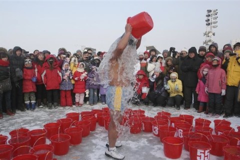 Jin Songhao, 54, pours a bucket of water onto himself during a cold endurance performance on the frozen Songhua River in Harbin