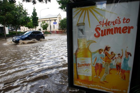 A car moves through a flooded street in the Brisbane suburb of West End