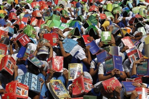 Students use their books to protect their heads during a earthquake drill in Baclaran