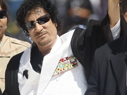 Libya's leader Muammar Gaddafi gestures as he arrives for a final round table session at the G8 summit in L'Aquila