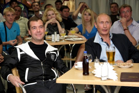 Russia's President Medvedev and Prime Minister Putin drink beer while watching the international friendly soccer match between Argentina and Russia in Sochi