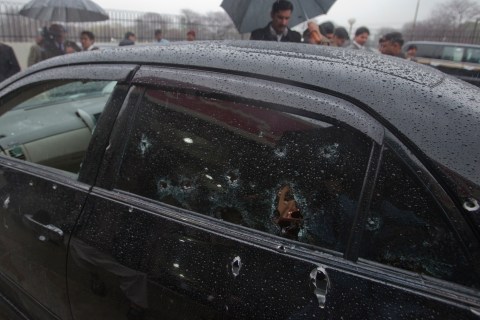 Security officials examine the bullet-riddled car of slain Pakistan's Minister for Minorities Bhatti outside the emergency ward of a hospital in Islamabad