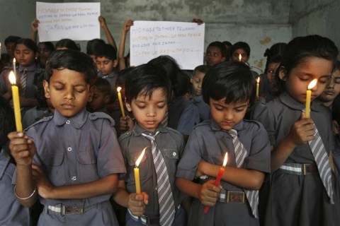 Students hold candles during a prayer ceremony for victims of the Japan earthquake and tsunami in Hyderabad