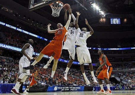 Bucknell University's Mike Muscala fights for a rebound with  University of Connecticut's Alex Oriakhi  and Roscoe Smith in Washington