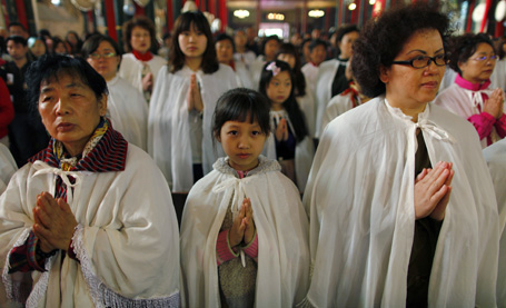 Christians pray during an Easter Sunday mass at the state-controlled Xishiku Cathedral in Beijing