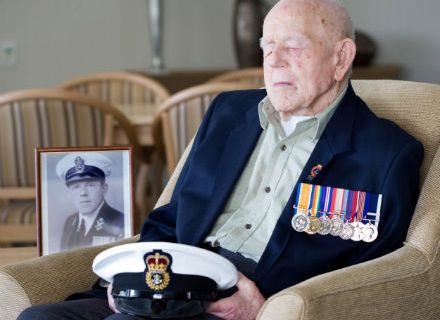 World War I veteran Claude Choules sits next to a portait of himself as a young sailor at Gracewood Retirement Village in Perth