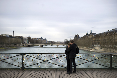 A couple kisses on the Pont des Arts, on