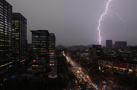 Lightning strikes over buildings during a thunderstorm in Beijing