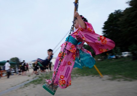 Okutama rides a swing at an evacuation centre on the eve of Japan's annual  Buddhist ceremony Obon in Kesennuma