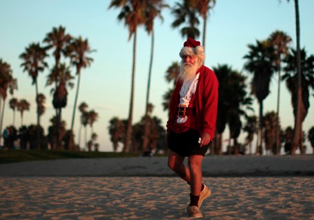 A man dressed as Santa Claus walks on Venice Beach in Los Angeles