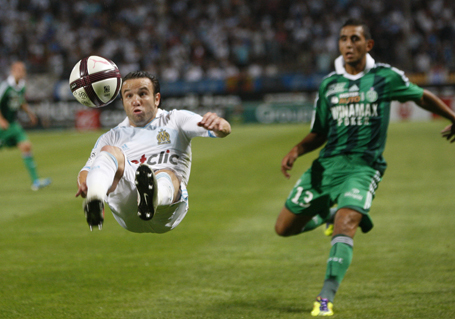 Olympique Marseille's Mathieu Valbuena attempts a kick in front of Saint-Etienne's Faouzi Ghoulam during their French Ligue 1 soccer match at the Velodrome Stadium in Marseille